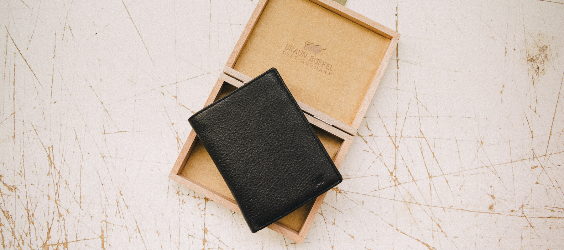 Schwarze Geldbörse liegt auf einer Holz Packung