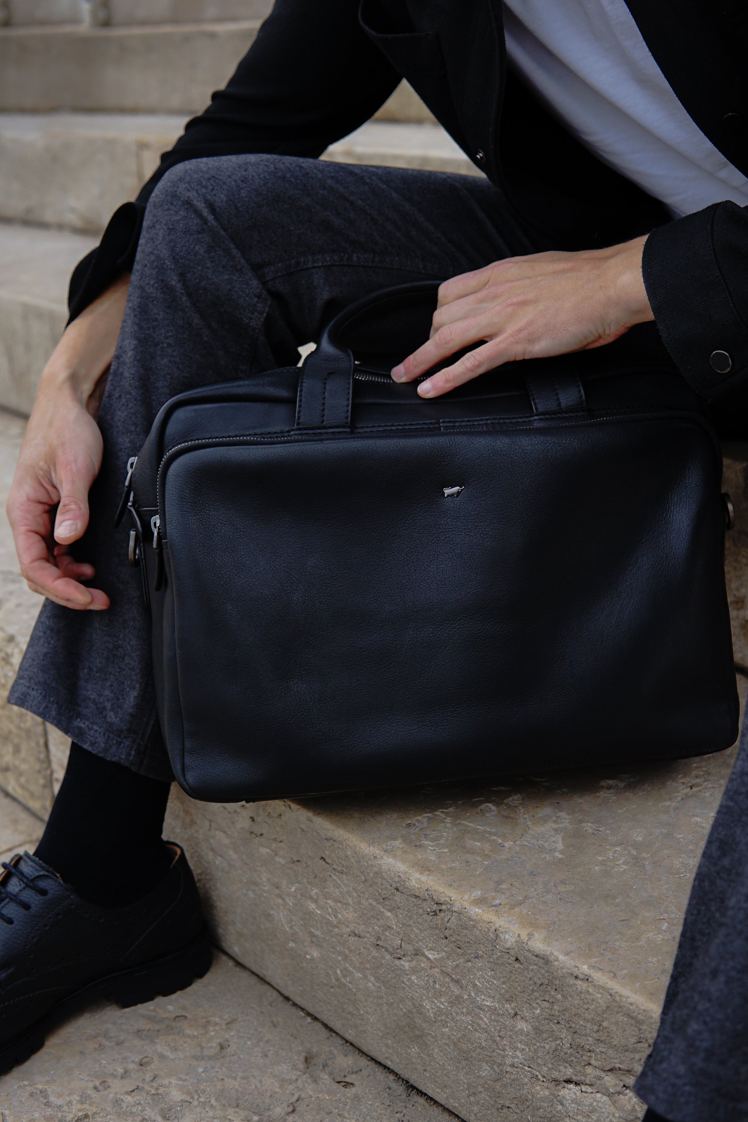 Schwarze Leder Business Tasche steht auf den Treppen