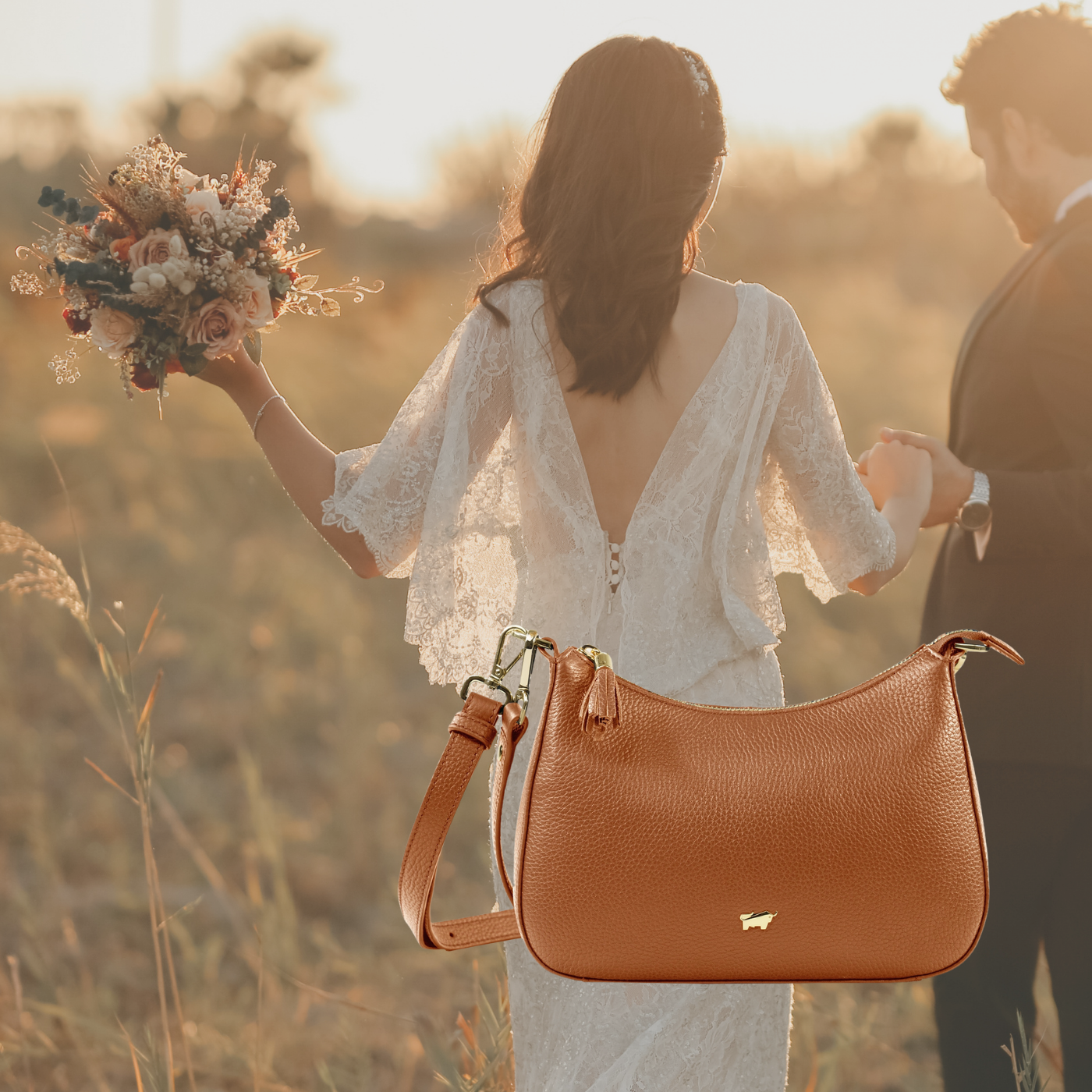 Romantischer Spitzenkleid-Hochzeitsstil mit Wildblumen und Ledertasche