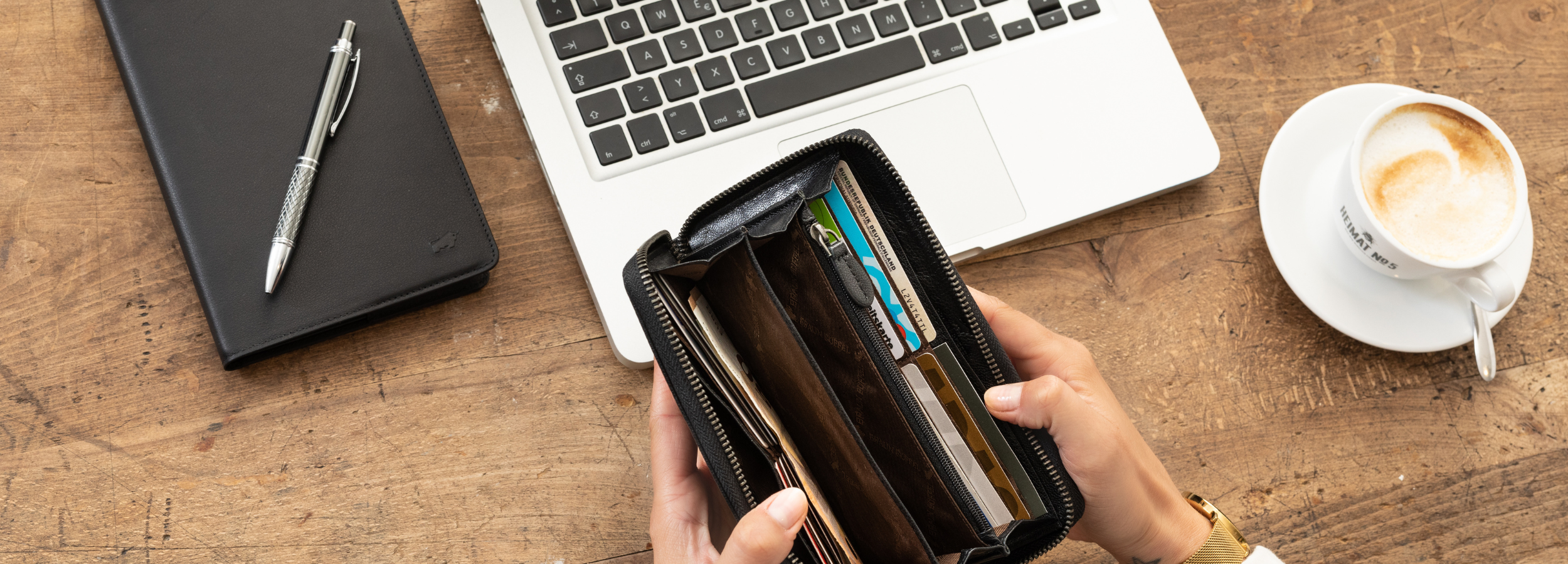 Frau hält schwarze Geldbörse auf