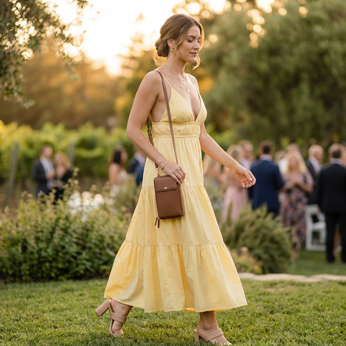 Frau auf einer Gartenhochzeit mit cognacfarbiger Handtasche