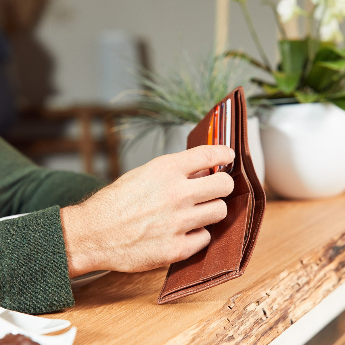 Mann hält eine braune Geldbörse in der Hand