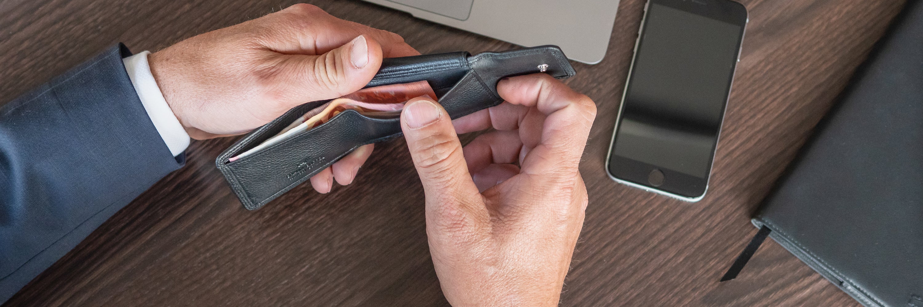 Mann hält eine schwarze Geldbörse