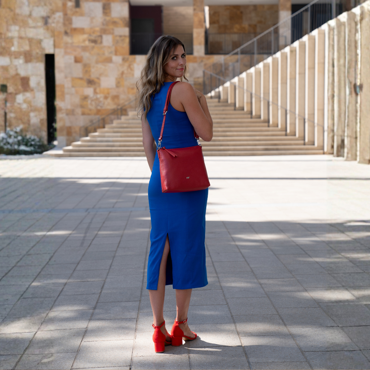 Frau auf einer City-Hochzeit mit schicker roter Handtasche