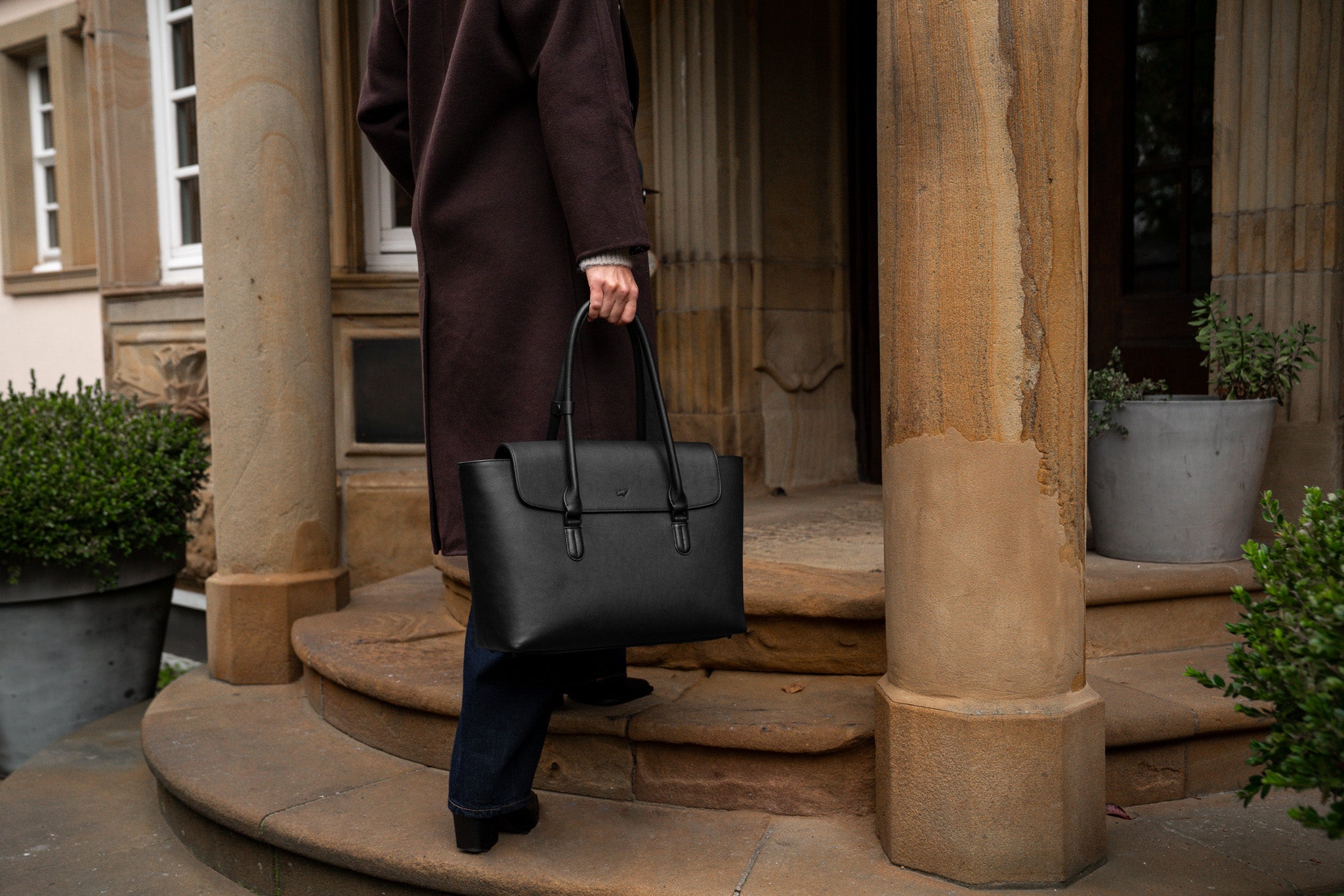 Eine Frau mit schwarzer Ledertasche im Carolyn_Bessette-Kennedy-Stil