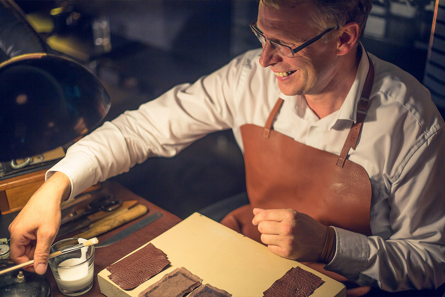 Ein Mann der mit Lederkleber arbeitet