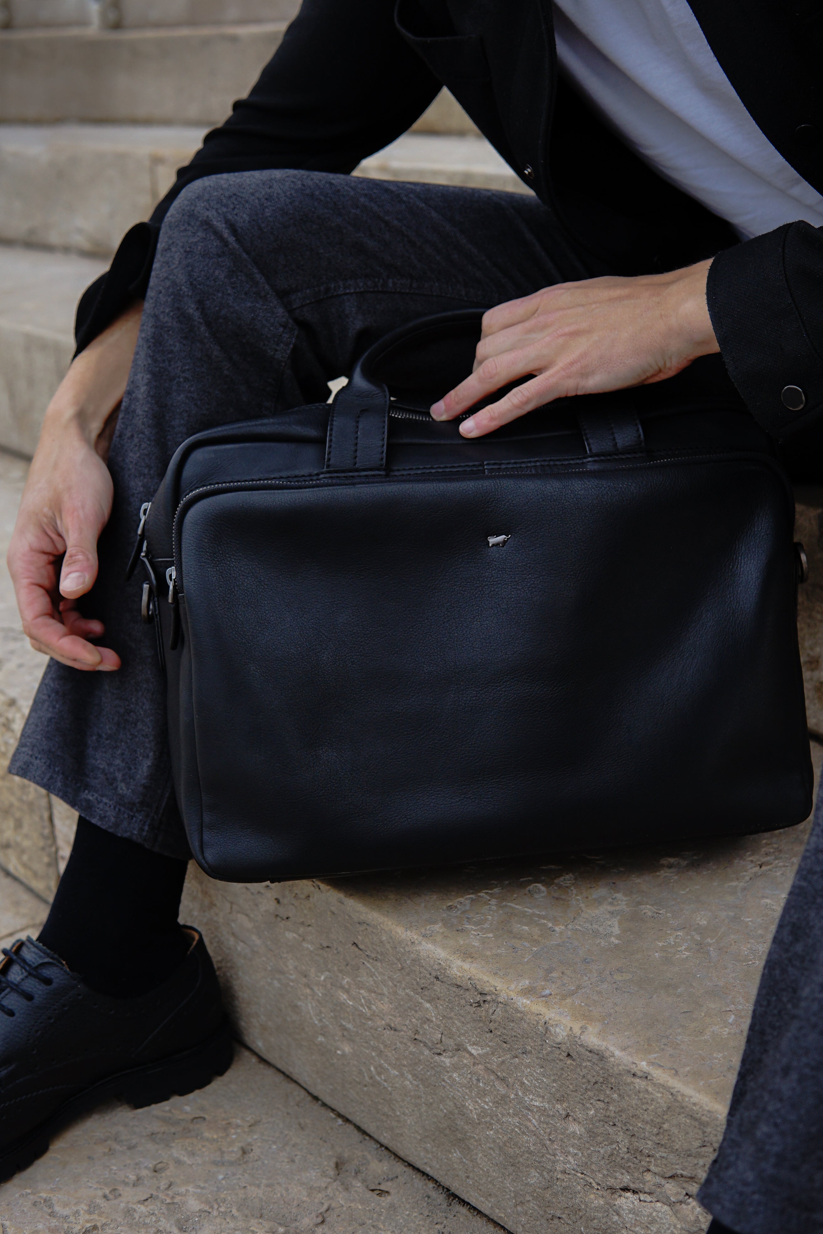 Schwarze Leder Business Tasche steht auf den Treppen 