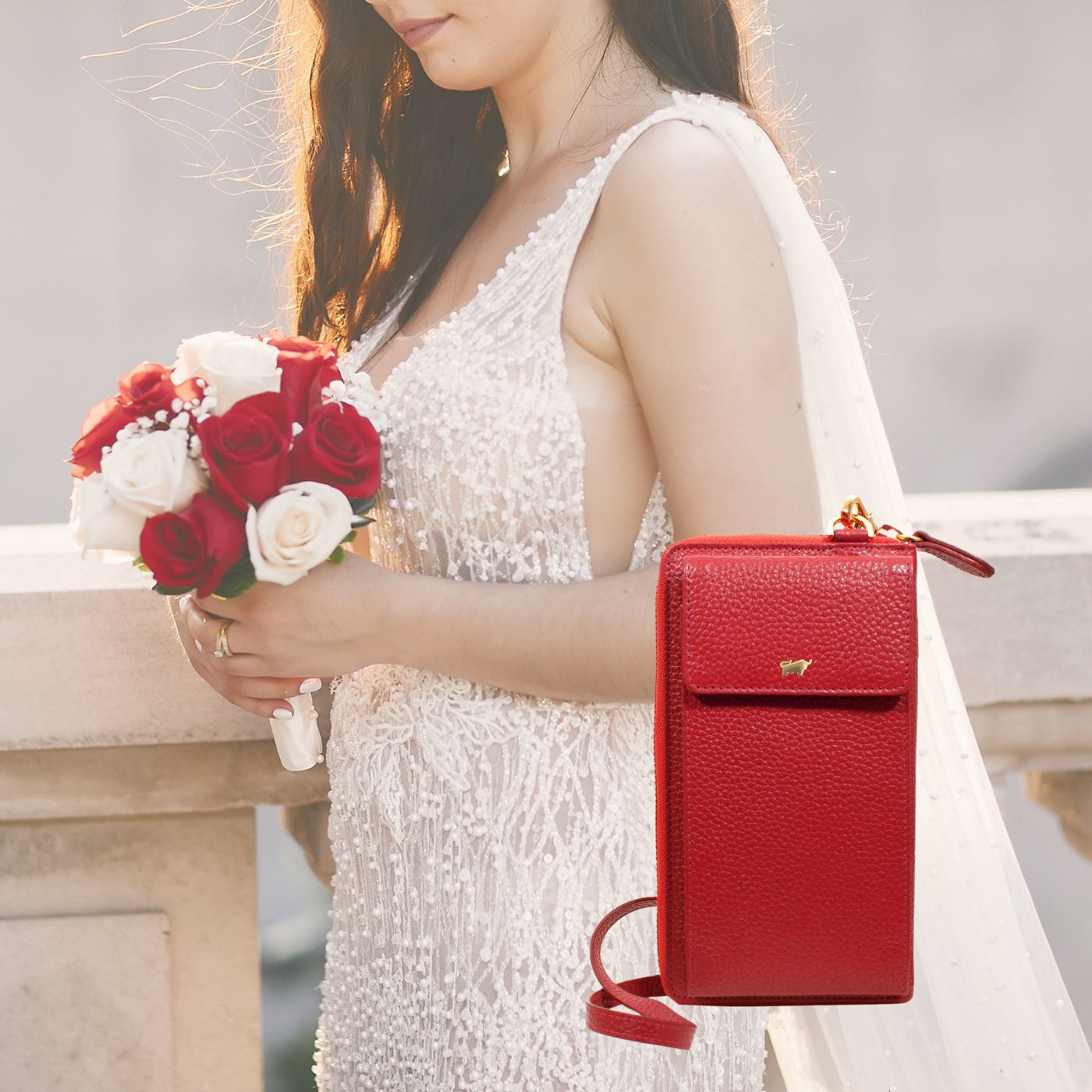 verführerisches Hochzeitsoutfit mit roter Ledertasche und roten Rosen