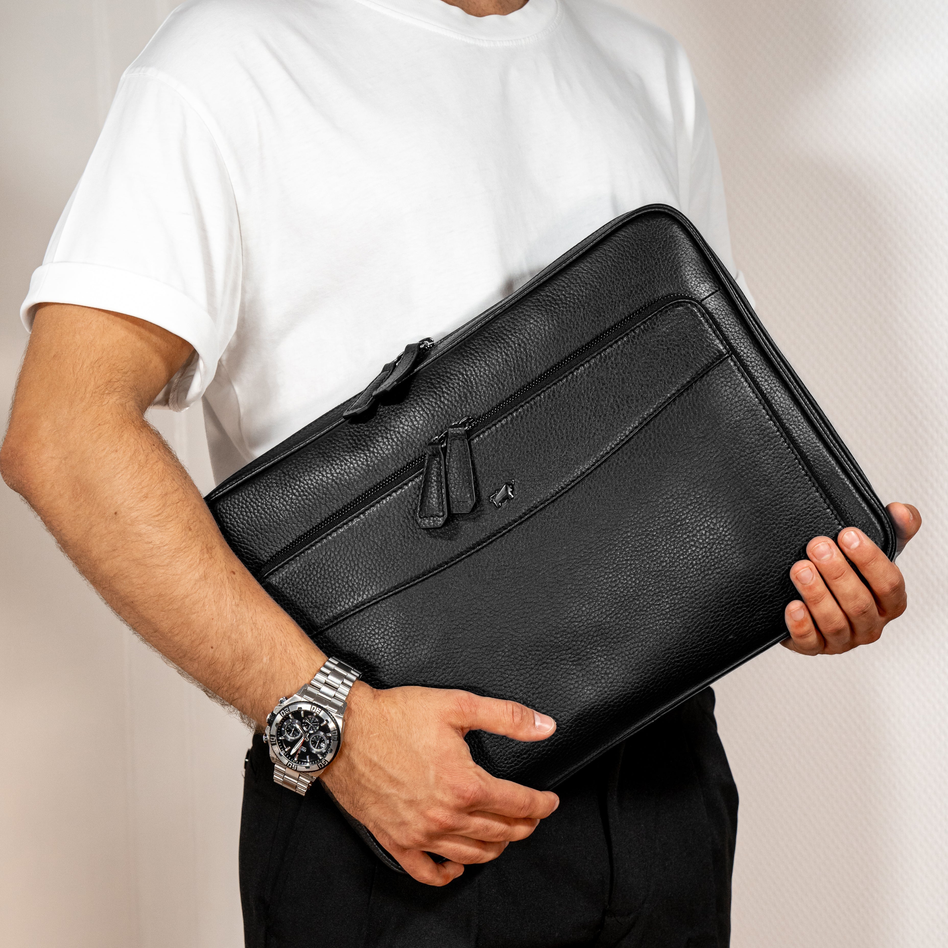 Mann trägt einen schwarze Leder-Laptop Mappe