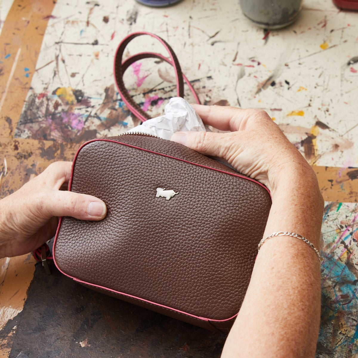 braune Ledertasche in der Hand einer Frau